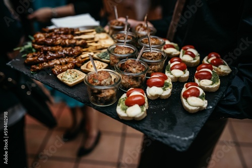 Array of savory appetizers arranged on a platter is presented at a festive event © Kristina Kirsten/Wirestock Creators