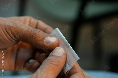 view of the hands of a man rolling a cigarette