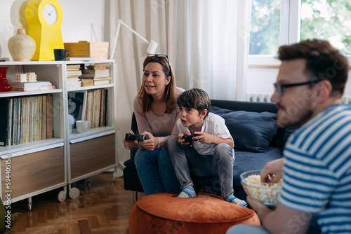 Mother and son play the video game together at home