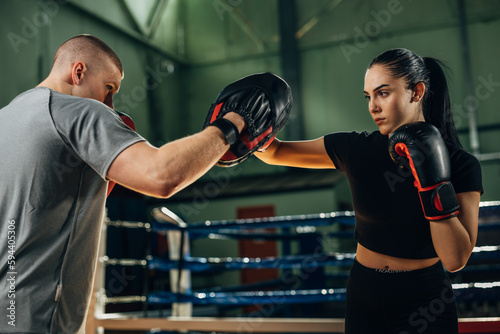 A woman practices punching in the ring with her partner