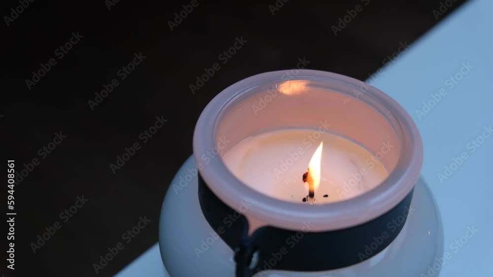 A large candle with a burning wick. A large candle with a burning wick.