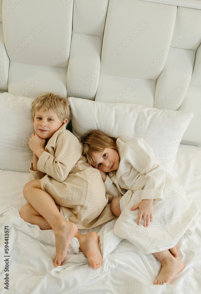 The brothers lie on the bed in bathrobes after a shower