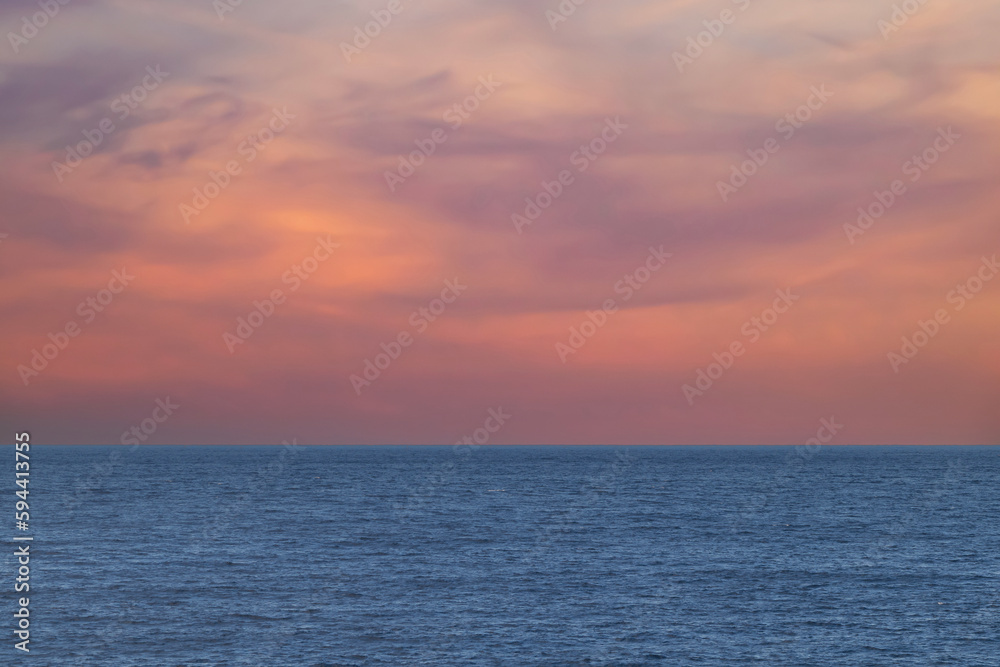 A view of a wide sea with a beautiful orange sky at sunset with free space for text, copy space