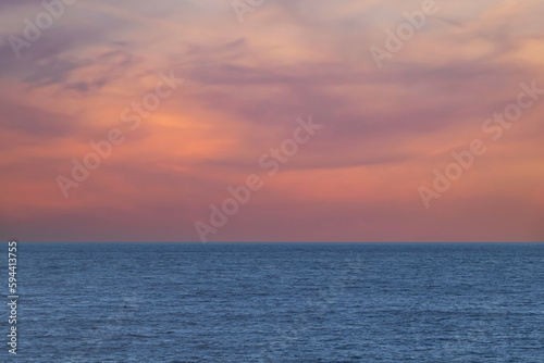A view of a wide sea with a beautiful orange sky at sunset with free space for text, copy space
