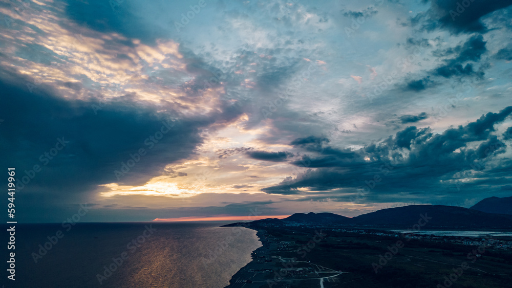Obraz premium Aerial view of a sunset over the sandy beach ad sea coast