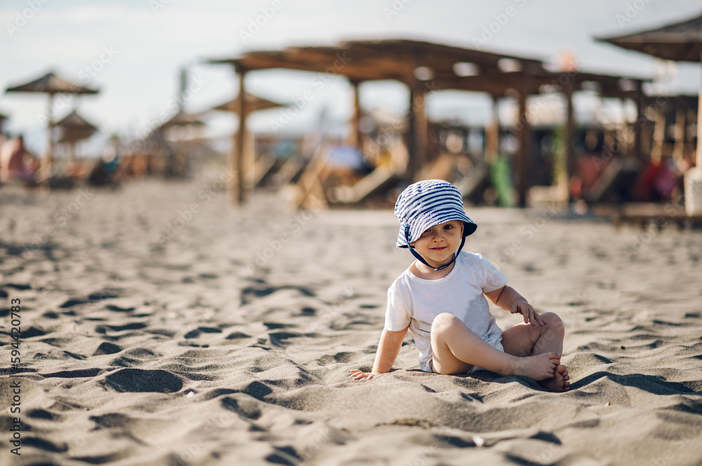 Adorable toddler child boy playing in the sand on a on beach