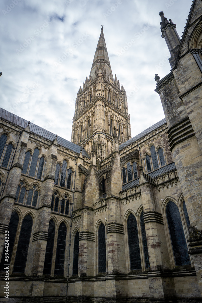 Salisbury Cathedral exterior with tallest church spire in United Kingdom. Early English Gothic structure with clerestory windows and North transept. Salisbury Cathedral exterior with tallest church spire in United Kingdom. Early English Gothic structure with clerestory windows and North transept.