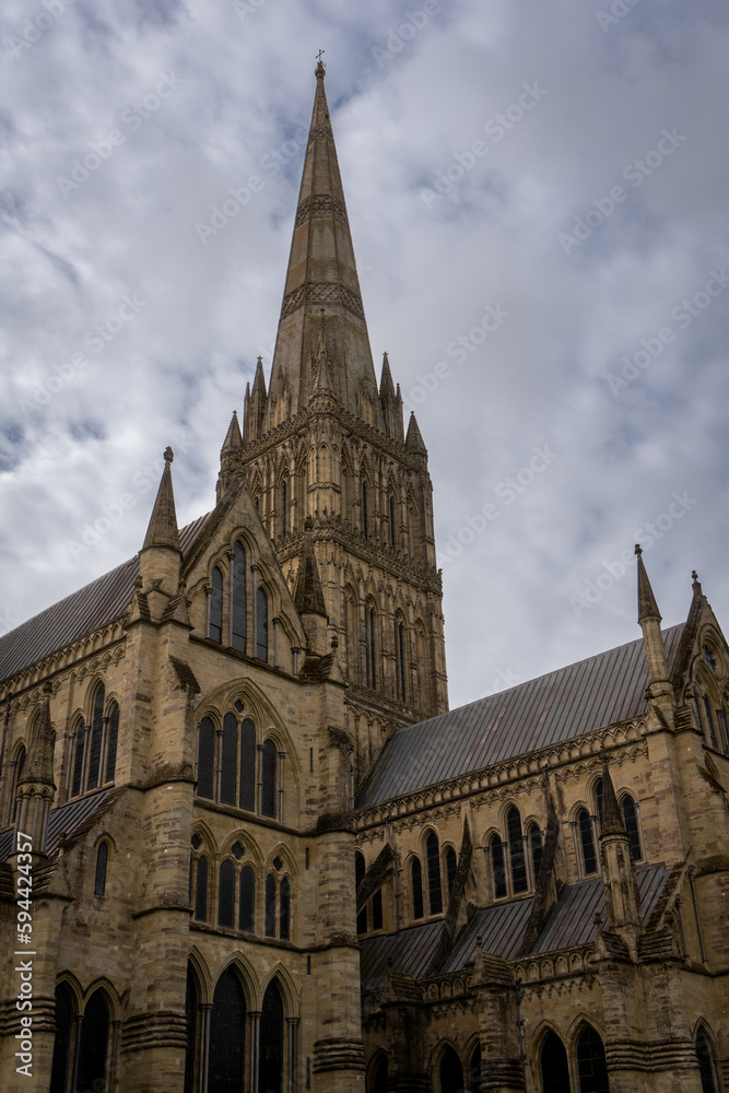 Salisbury Cathedral exterior with tallest church spire in United Kingdom.  Early English Gothic structure with clerestory windows and North transept.