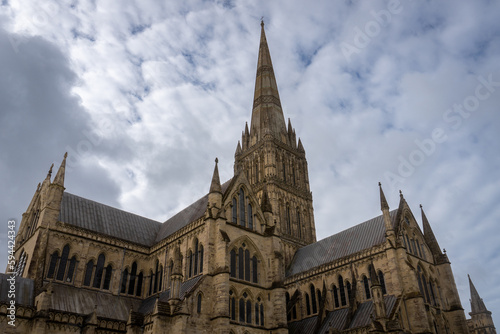 Salisbury Cathedral exterior with tallest church spire in United Kingdom. Early English Gothic structure with clerestory windows and North transept.