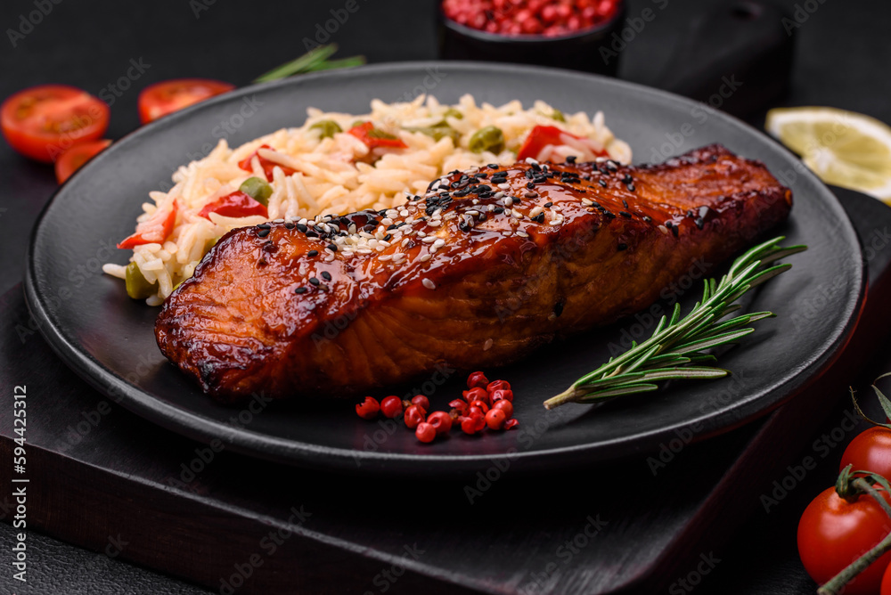 Delicious red salmon fish grilled with sauce and sesame seeds with rice and vegetables