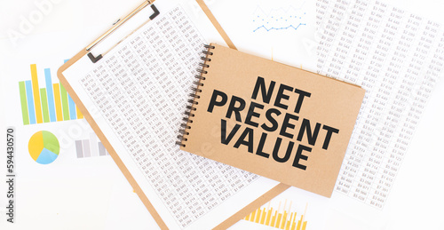 Text net present value on brown paper notepad on the table with diagram. Business concept