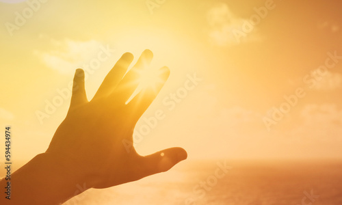 Hand reaching out touching the warm sunlight 