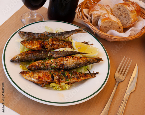 Deliciously fried many sardines served with lemon at plate, nobody