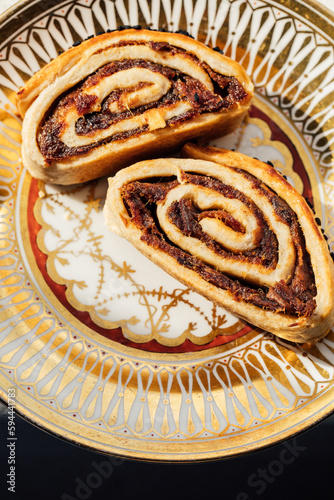 Kleicha, Iraqi date cookies in spiral form with nigella seeds on ornate gold pattern plate photo