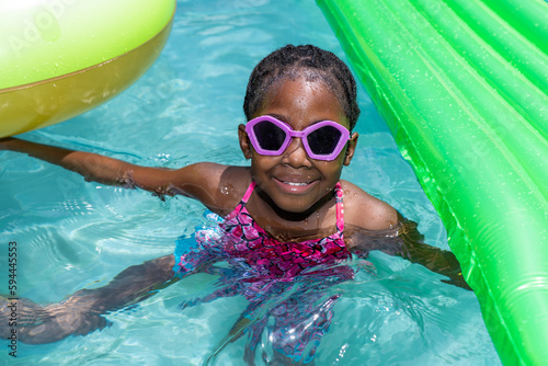 Young girl smiling and having fun in an outdoor swimming pool