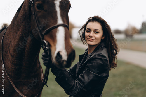 A young equestrian in uniform poses with a beautiful, majestic horse.