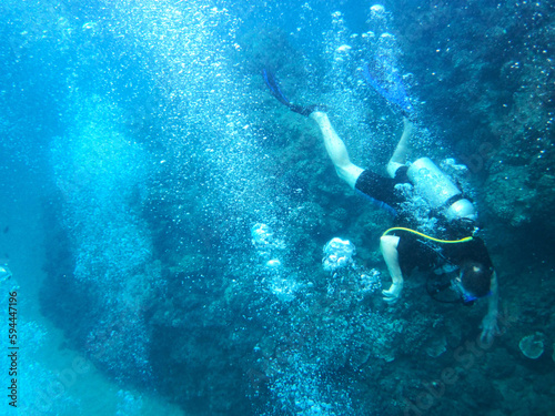 image of diver swimming underwater with lots of air bubbles
