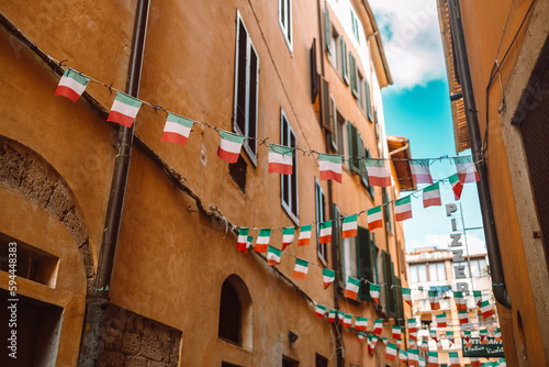 Fototapeta Naklejka Na Ścianę i Meble -  Holiday in the Italian city of streets with Italian flags and ancient buildings.Pisa, Italy.