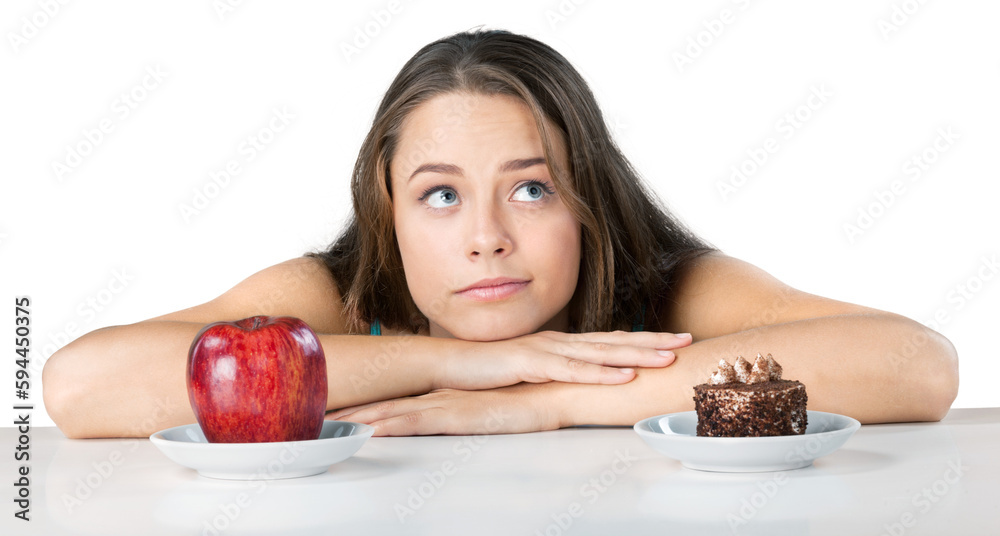 Attractive young woman makes her choice between apple and cake, healthy lifestyle concept Attractive young woman makes her choice between apple and cake, healthy lifestyle concept