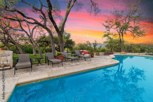 a luxury pool at sunset with a gazebo 