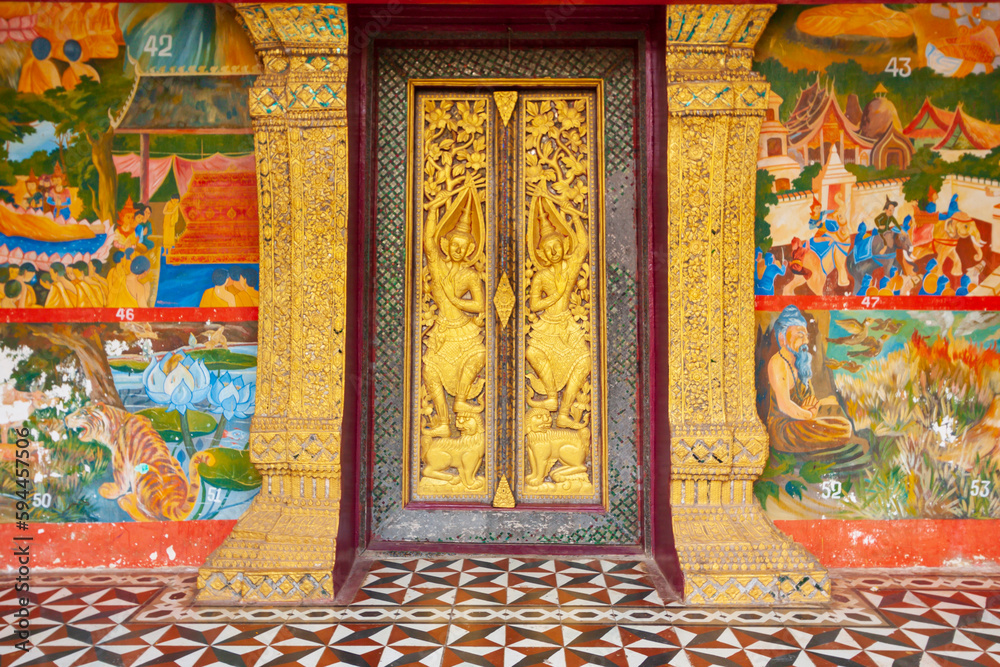 Laos, Luang Prabang. Ornate door and murals.