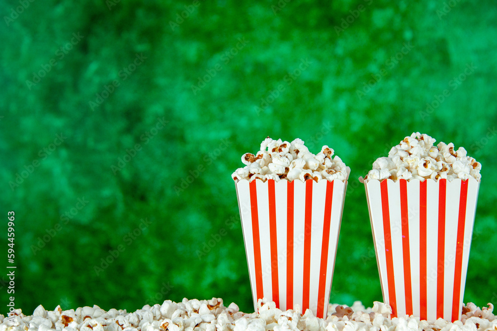front view fresh popcorn in white and red striped packages on green background snack cinema cips photo corn movie color free place