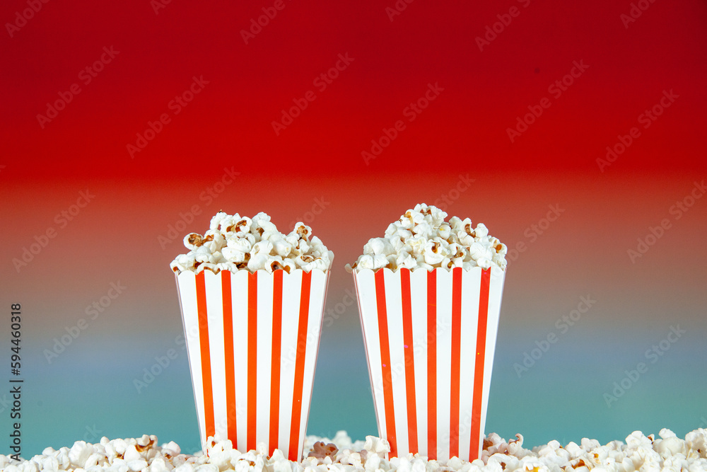 front view fresh popcorn in white and red striped packages on light red background snack cinema cips color photo corn movie