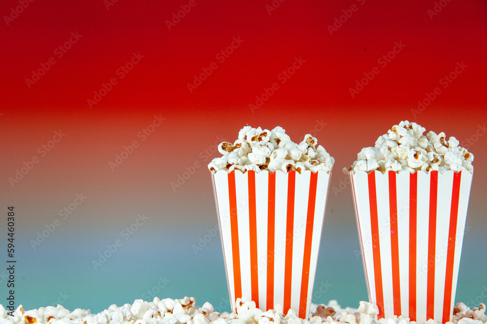 front view fresh popcorn in white and red striped packages on light red background snack cinema cips color photo corn movies