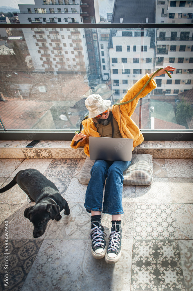 Foto de hipster teenage girl sitting on terrace cheerfully spreading