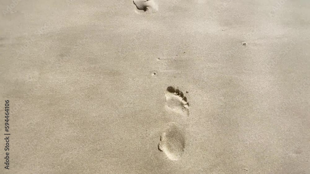 Footprints in the sand on the beach. The camera follows footprints in a large sand dune on the beach. 4k resolution video. Footprints in the sand on the beach. The camera follows footprints in a large sand dune on the beach. 4k resolution video.