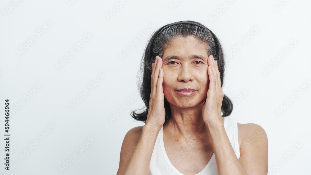 Close up face of female elderly mature older asian chinese housewife applies anti aging facial cream on face, old skincare treatment