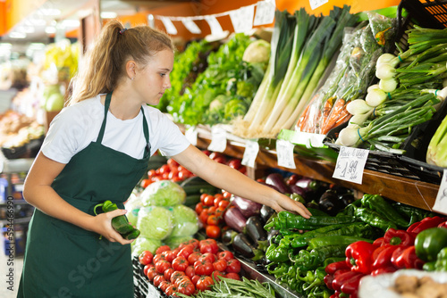 Obraz na plátně Focused fifteen-year-old girl who works part-time in a store as a trainee salesw
