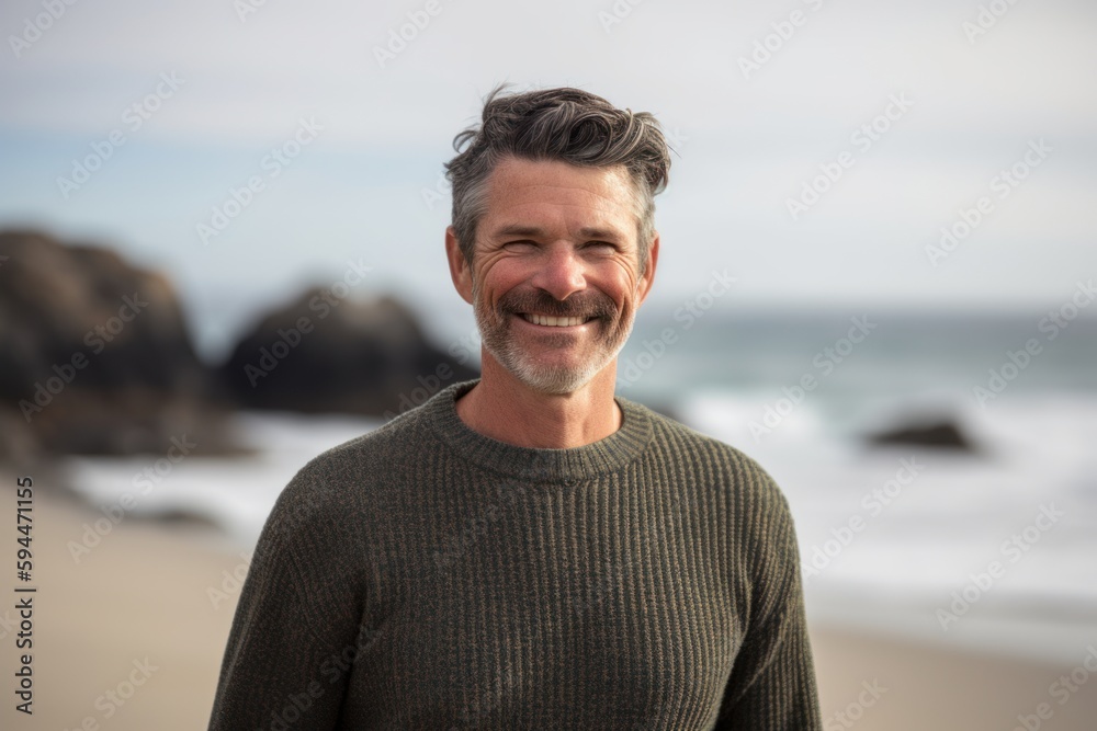 Portrait of happy mature man smiling at camera at beach during sunny day Portrait of happy mature man smiling at camera at beach during sunny day