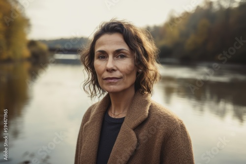 Portrait of a beautiful middle-aged woman on the background of autumn landscape