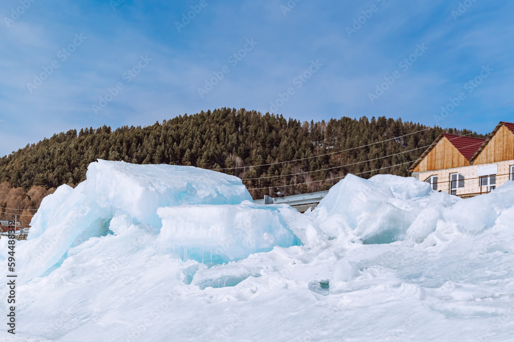 Lake Baikal in early spring. The village of Listvyanka is a popular travel destination. Ice mountains on the frozen Baikal Lake Baikal in early spring. The village of Listvyanka is a popular travel destination. Ice mountains on the frozen Baikal