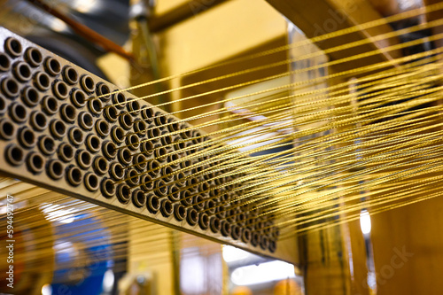 Bar with holes and strained wires in rolled steel workshop photo