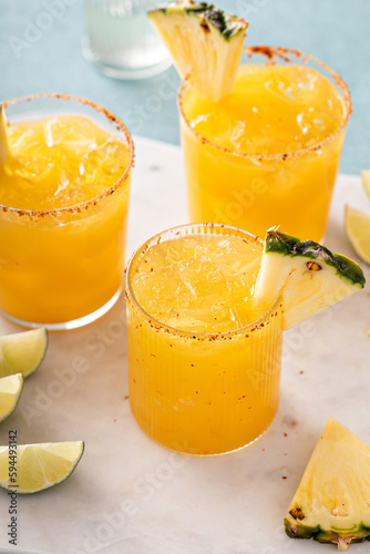 Pineapple margarita cocktail in glasses with tajin rim