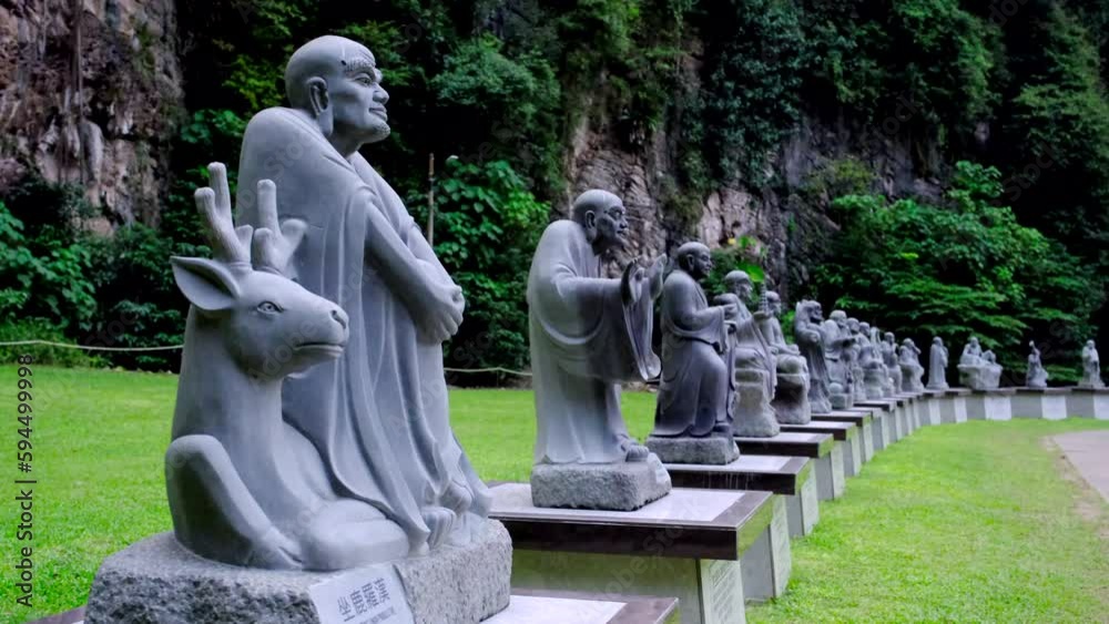 Multiple Buddha statues line up in the park with the mountain in the background. Multiple Buddha statues line up in the park with the mountain in the background.