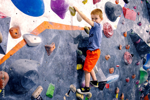 a boy climbs a climbing wall