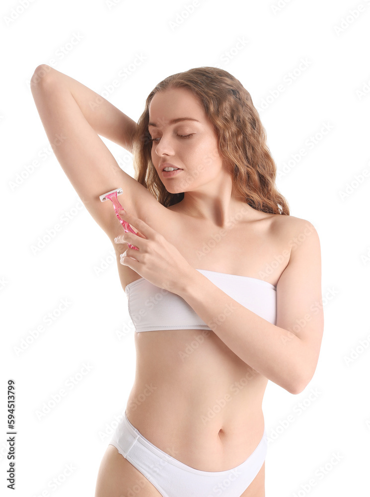 Fototapeta premium Young woman shaving her armpit with razor on white background