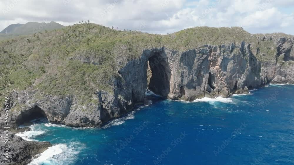 Dramatic cave, rock formation hole in steep clips at ocean coastline, aerial Dramatic cave, rock formation hole in steep clips at ocean coastline, aerial