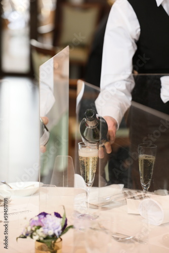 ウェディングアテンダーがシャンパンを注ぐ wedding attendant pours champagne