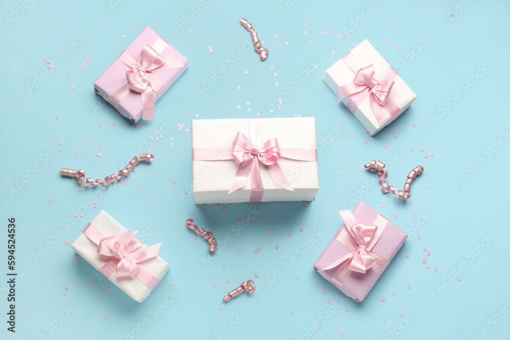 Gift boxes with beautiful bows, serpentine and confetti on blue background Gift boxes with beautiful bows, serpentine and confetti on blue background