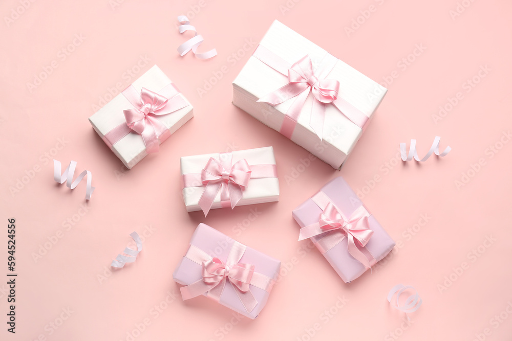 Gift boxes with beautiful bows and serpentine on pink background Gift boxes with beautiful bows and serpentine on pink background