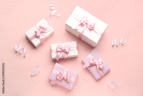 Fototapeta Naklejka Na Ścianę i Meble -  Gift boxes with beautiful bows and serpentine on pink background