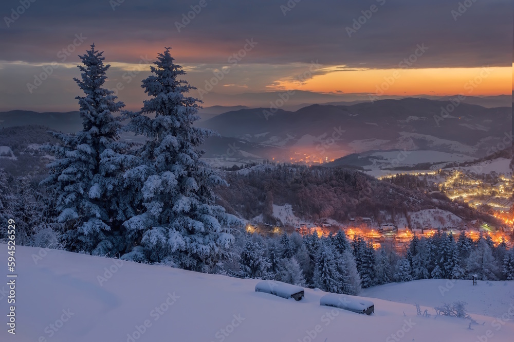 Panorama winter old City. Banska Stiavnica, Slovakia. Church at the top of the hill. Light of houses in the valley