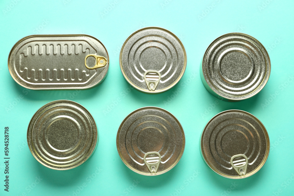 Assortment of tin cans with fish on turquoise background Assortment of tin cans with fish on turquoise background