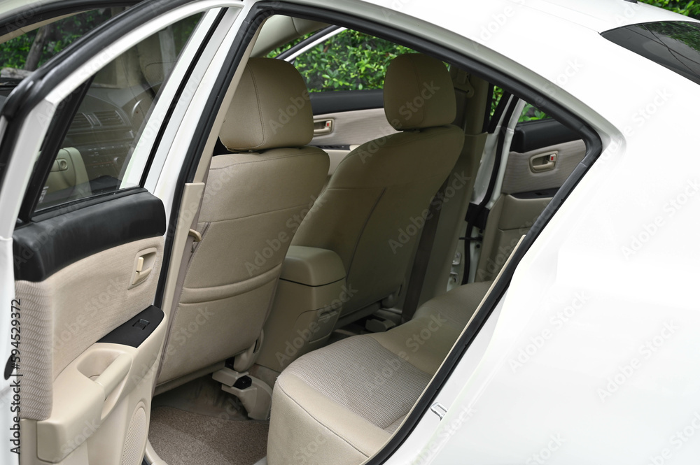inside the back seat The passenger seat is wide and clean. Leather interior design, car passenger and driver seats, clean, angle view side, sunroof solar, buttons, dashboard, nappa leather, beige.