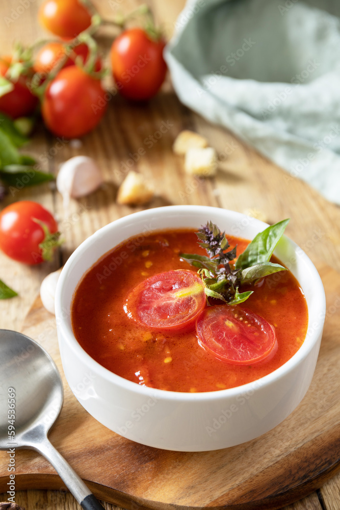 Vegan soup puree tomatoes. Healthy diet low carb. Bowl of tomato cream soup with basil and croutons on a rustic table. Vegan soup puree tomatoes. Healthy diet low carb. Bowl of tomato cream soup with basil and croutons on a rustic table.