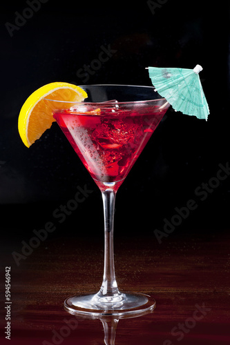 Sea Breeze cocktail in martini glass against black background photo